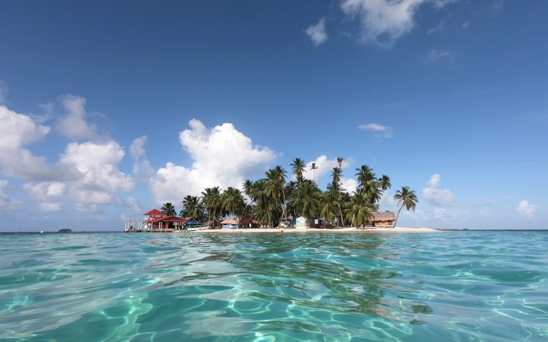 An idylic paradise island of the San Blas Islands, Panama, also known as Guna Yala, with crystal-clear water, palm trees, and white sand beaches- a perfect tropical destination to visit with San Blas tours.
