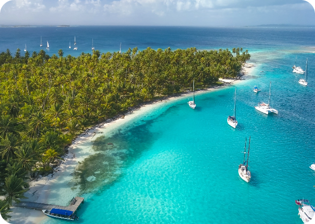Aerial view of Chichime Island in the San Blas Archipelago, Panama, with a sailboats anchored off the white-sand beach and turquoise water — one of the best island to stay overnight with a San Blas tours from Panama City.